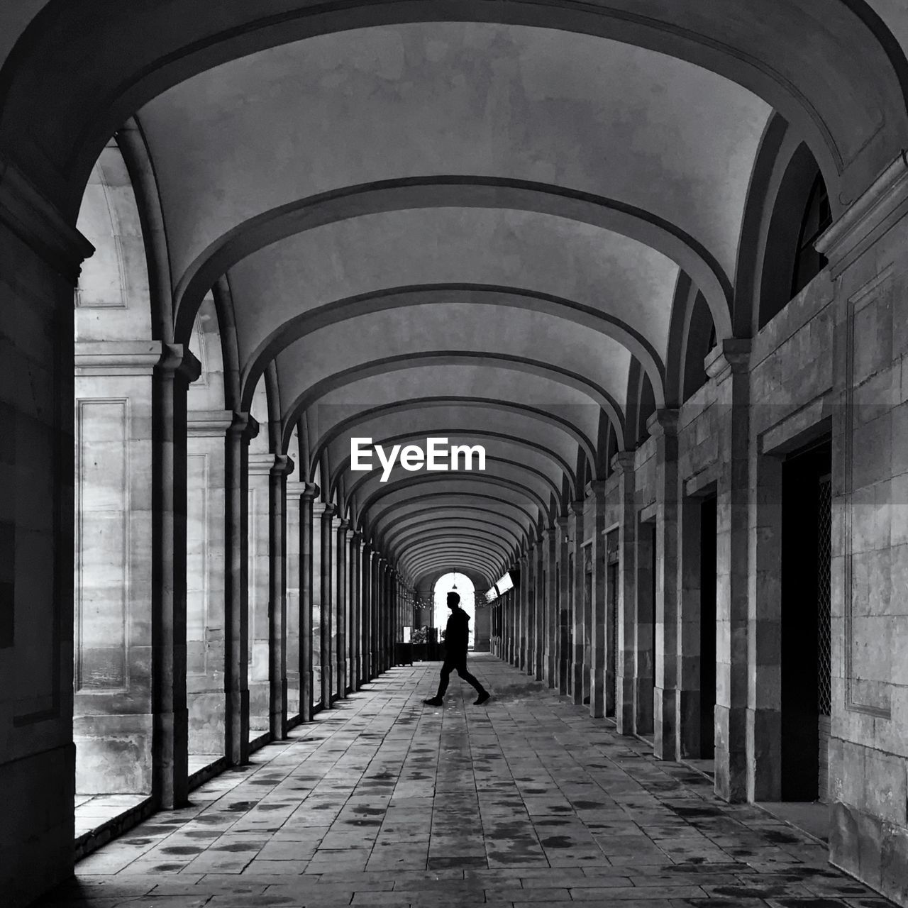 REAR VIEW OF WOMAN WALKING IN CORRIDOR OF BUILDING