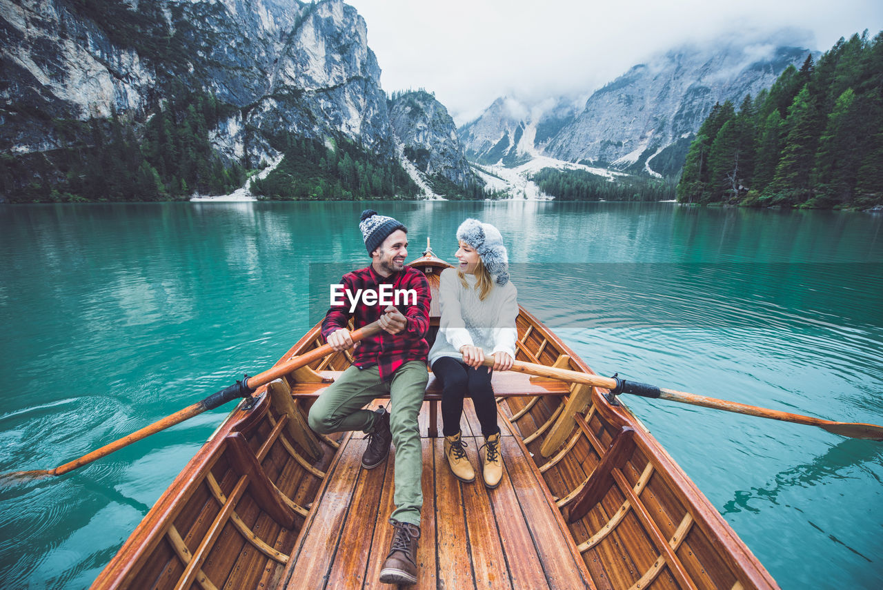 FRIENDS SITTING ON BOAT IN LAKE