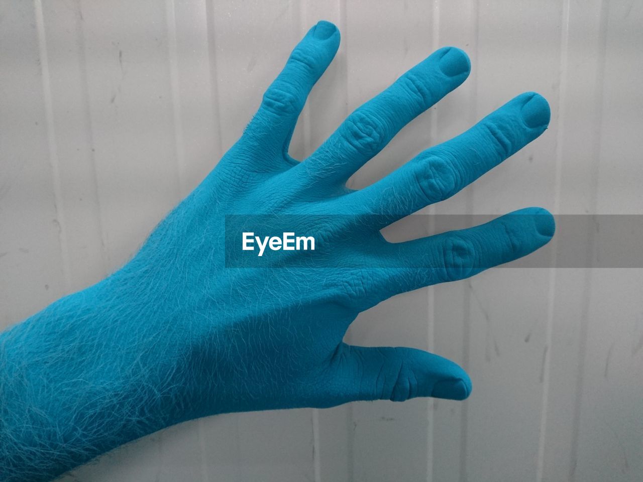CLOSE-UP OF HAND ON BLUE FINGER