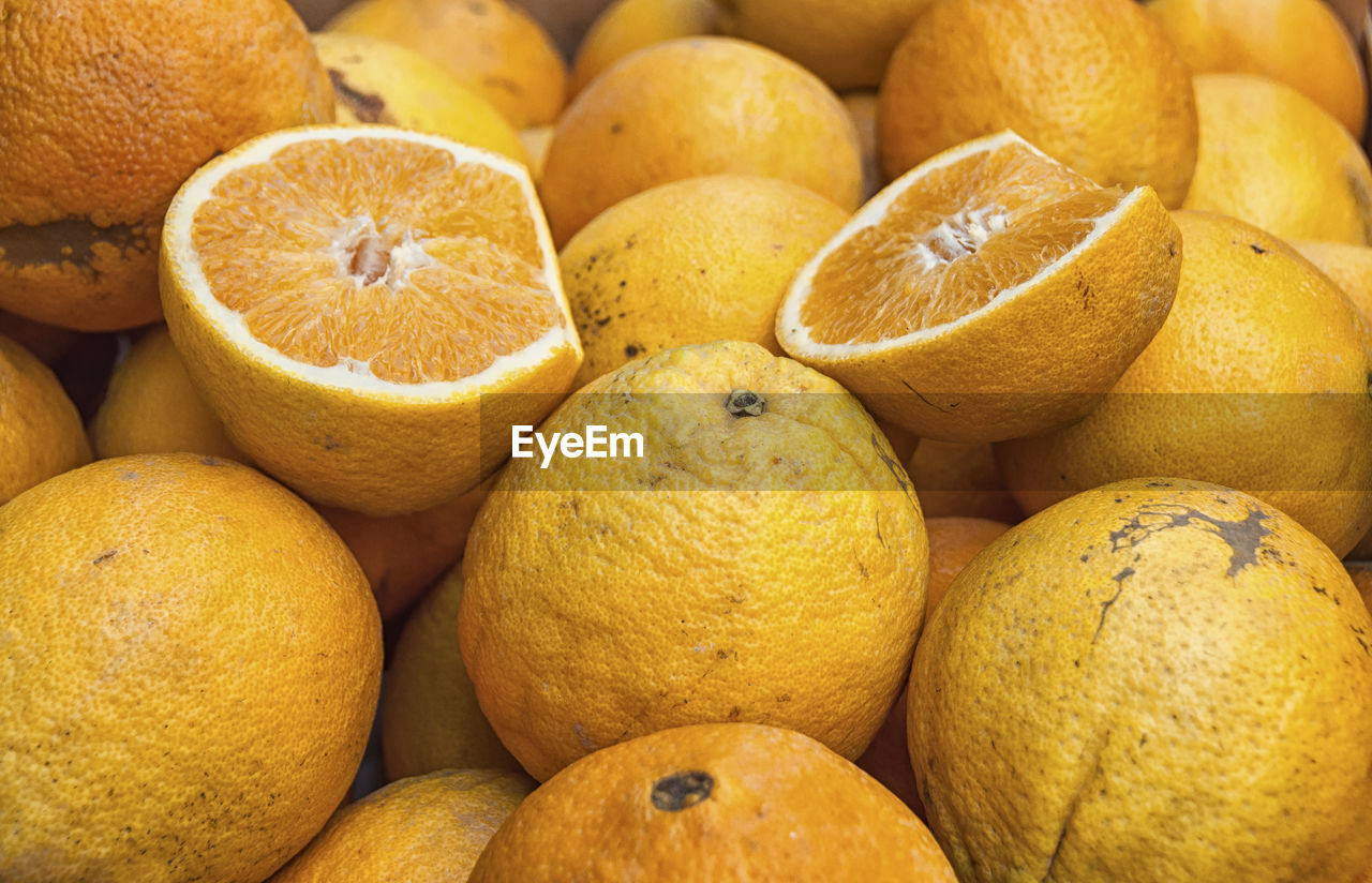 Full frame shot of whole and halved oranges