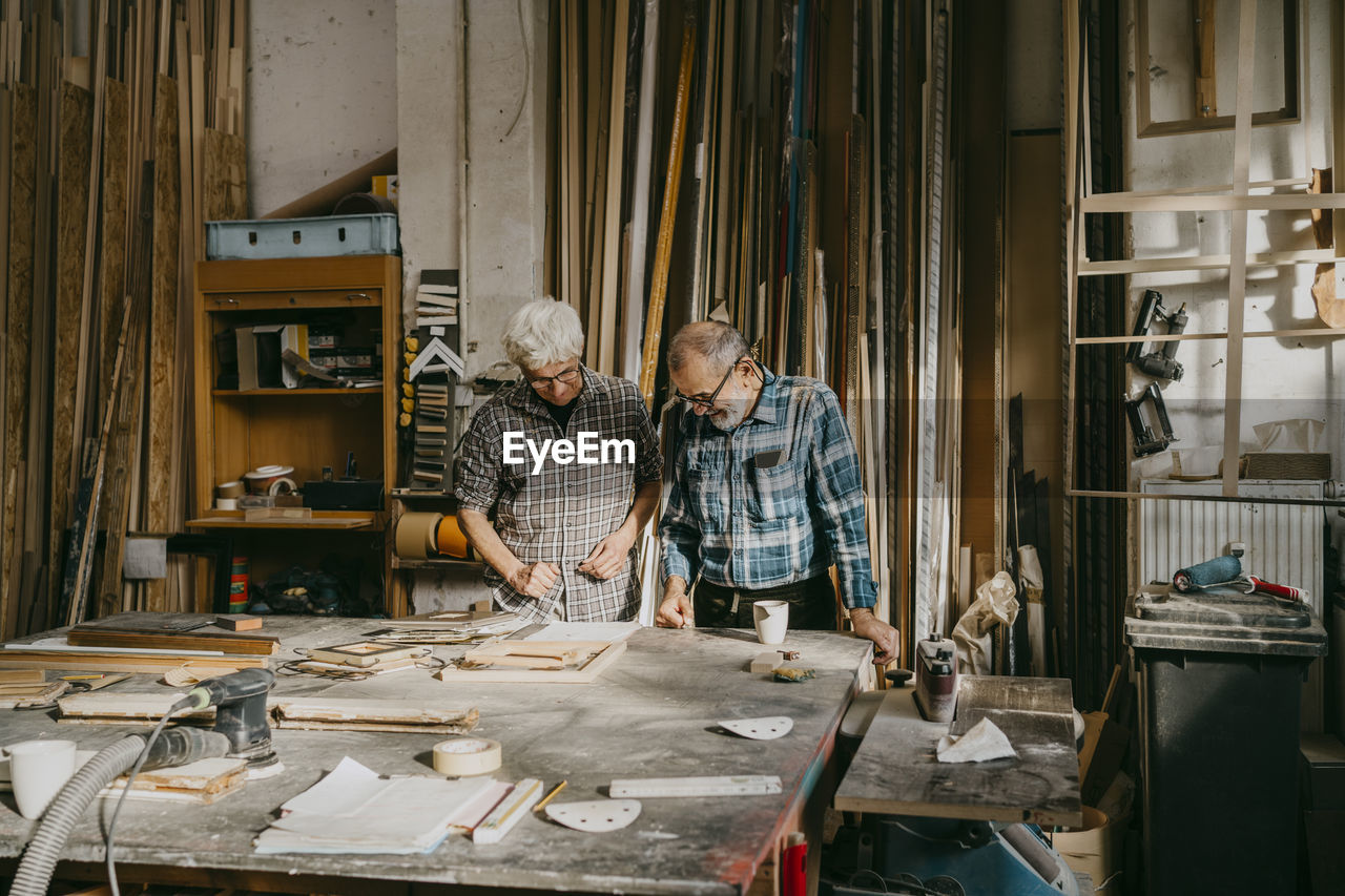 Senior craftsmen working together at carpentry workshop