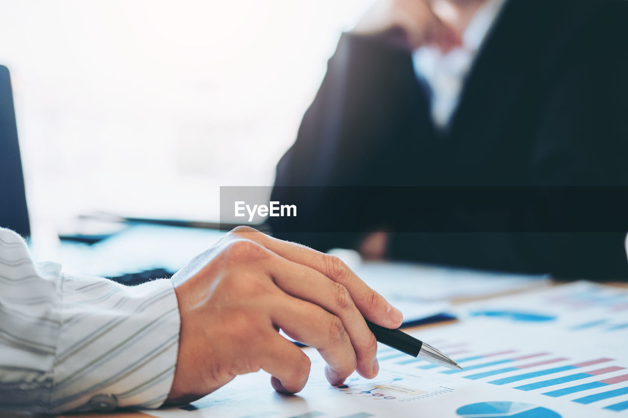 Cropped image of business colleagues working at desk in office