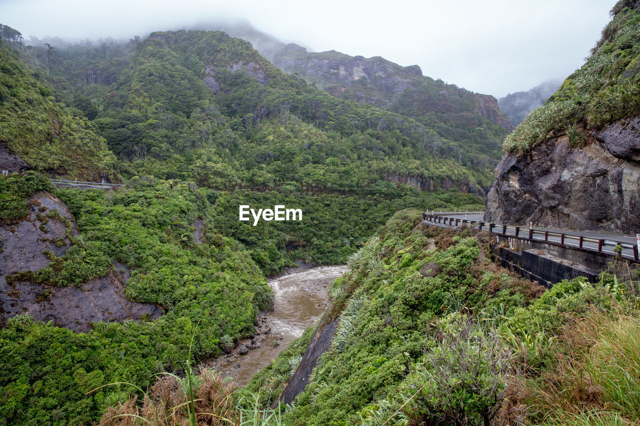 SCENIC VIEW OF WATERFALL AGAINST SKY