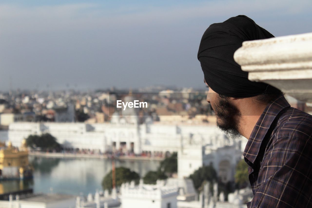 Side view of young man looking at cityscape