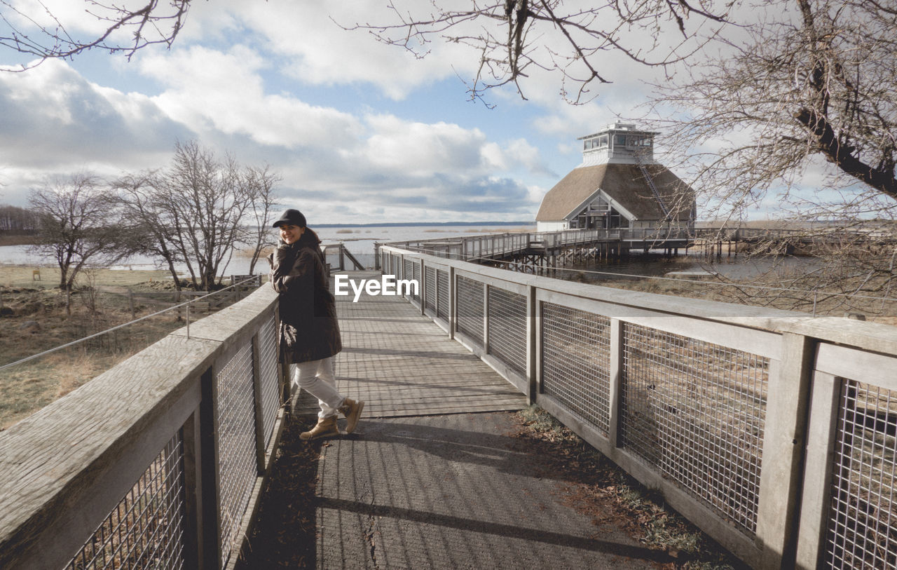 Man standing on bridge against sky