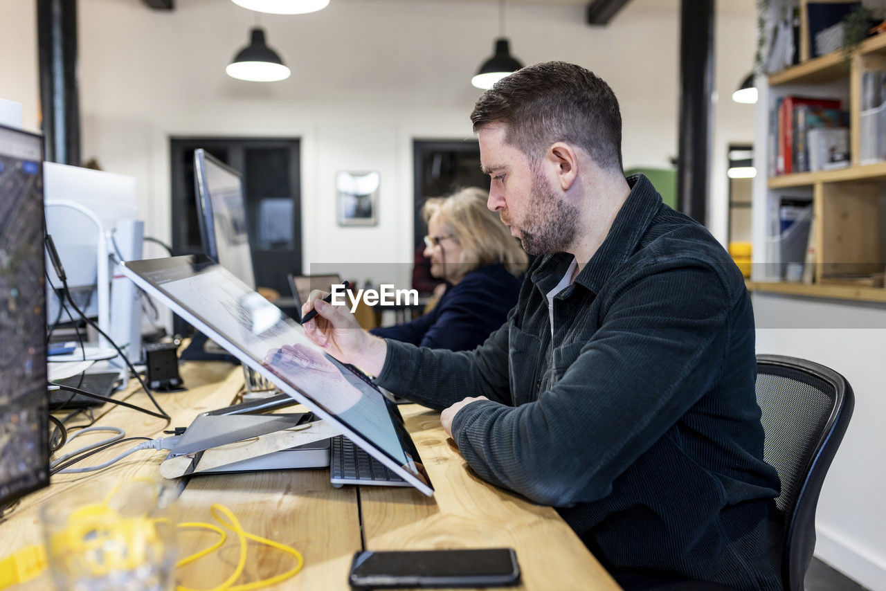 Architect working on graphics tablet at desk