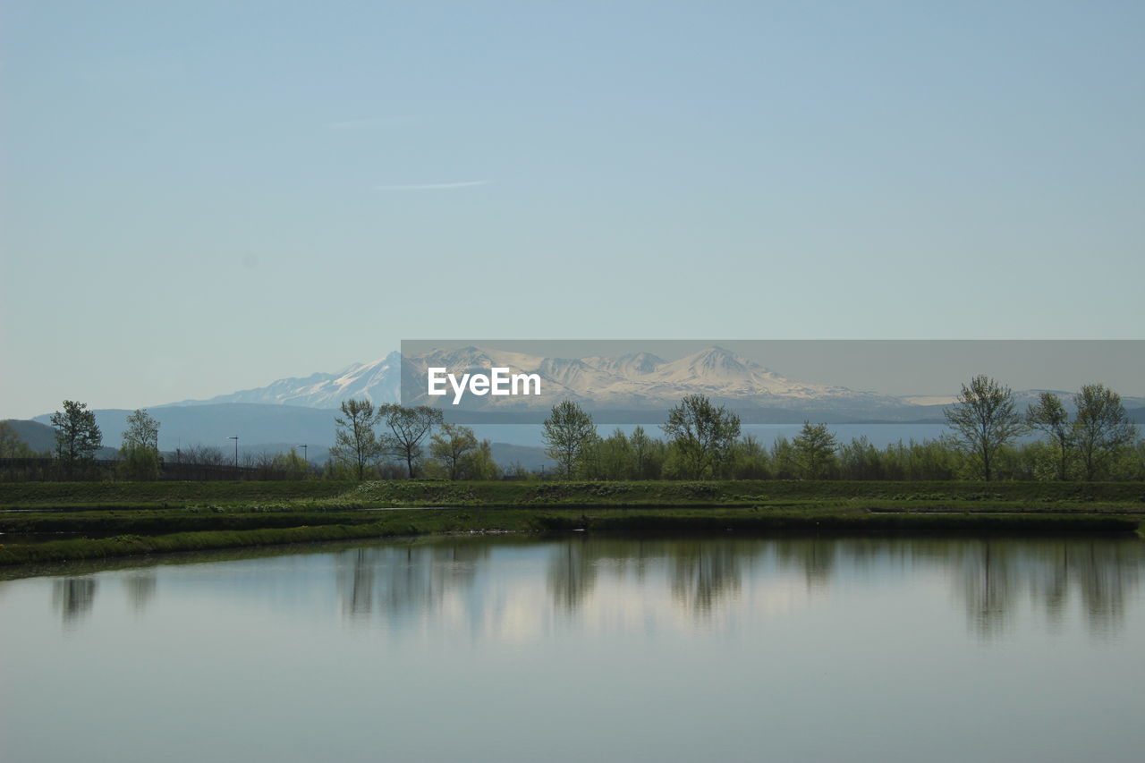 Scenic view of lake by mountains against sky