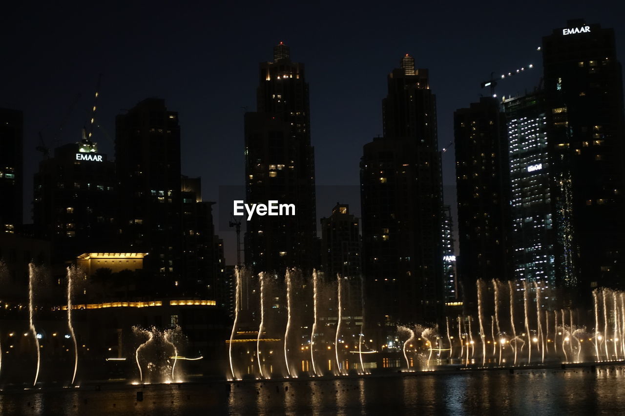 ILLUMINATED CITY BUILDINGS AT NIGHT