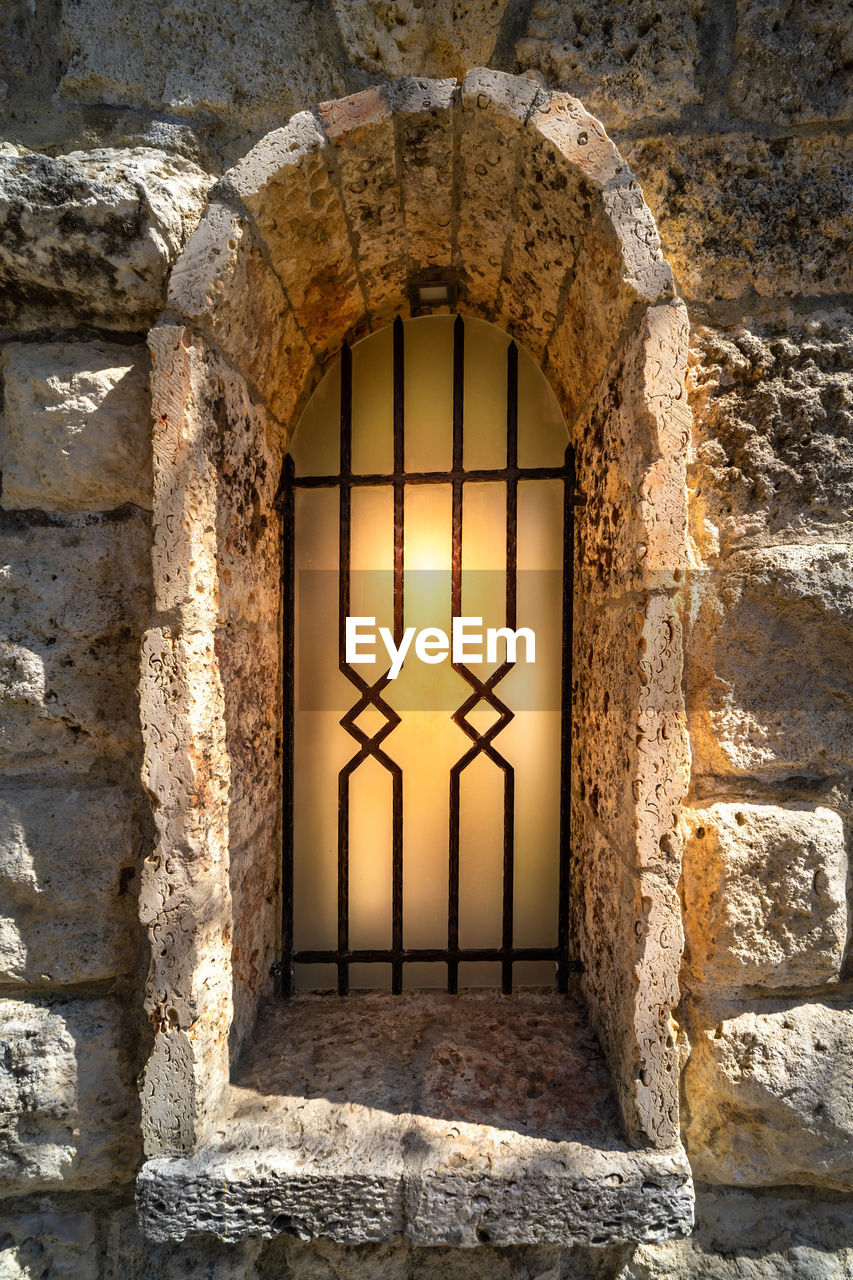 Window with metal bars on stone wall