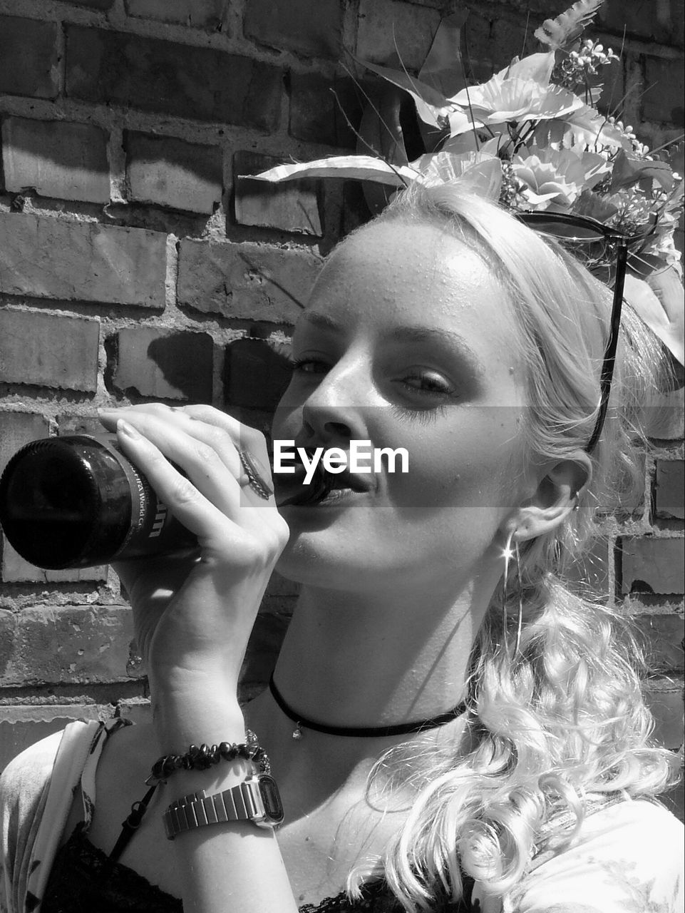 PORTRAIT OF YOUNG WOMAN DRINKING WATER FROM OUTDOORS