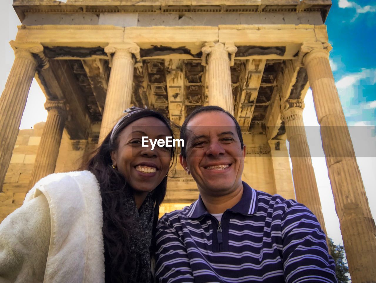 Portrait of smiling couple against built structure