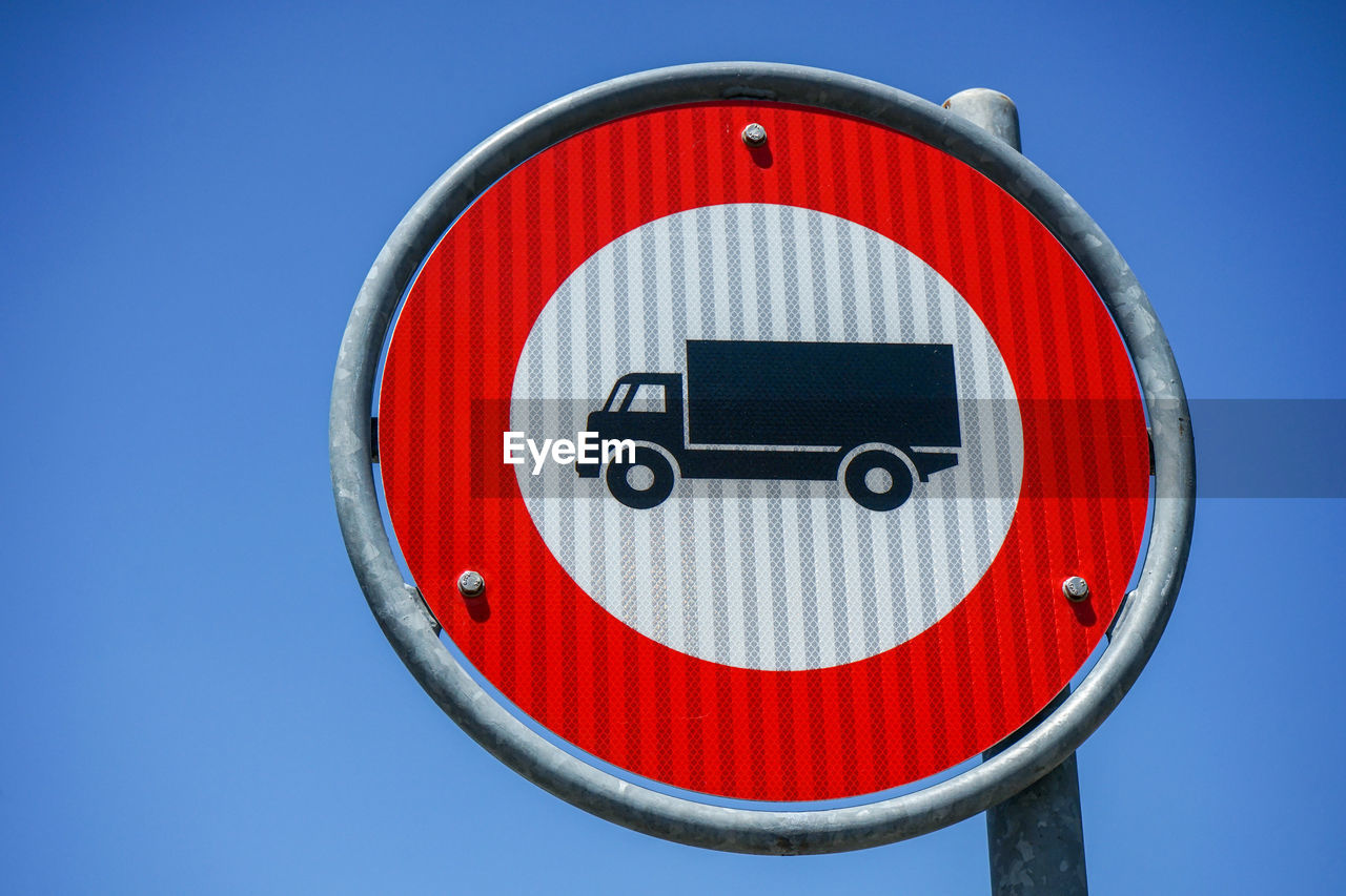 CLOSE-UP OF ROAD SIGN AGAINST CLEAR SKY