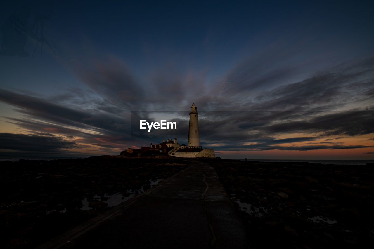 SCENIC VIEW OF ILLUMINATED LAND AGAINST SKY AT SUNSET