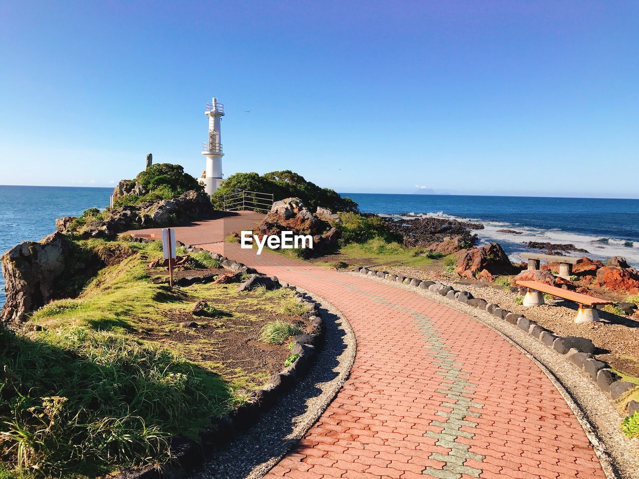 Scenic view of sea and buildings against clear blue sky