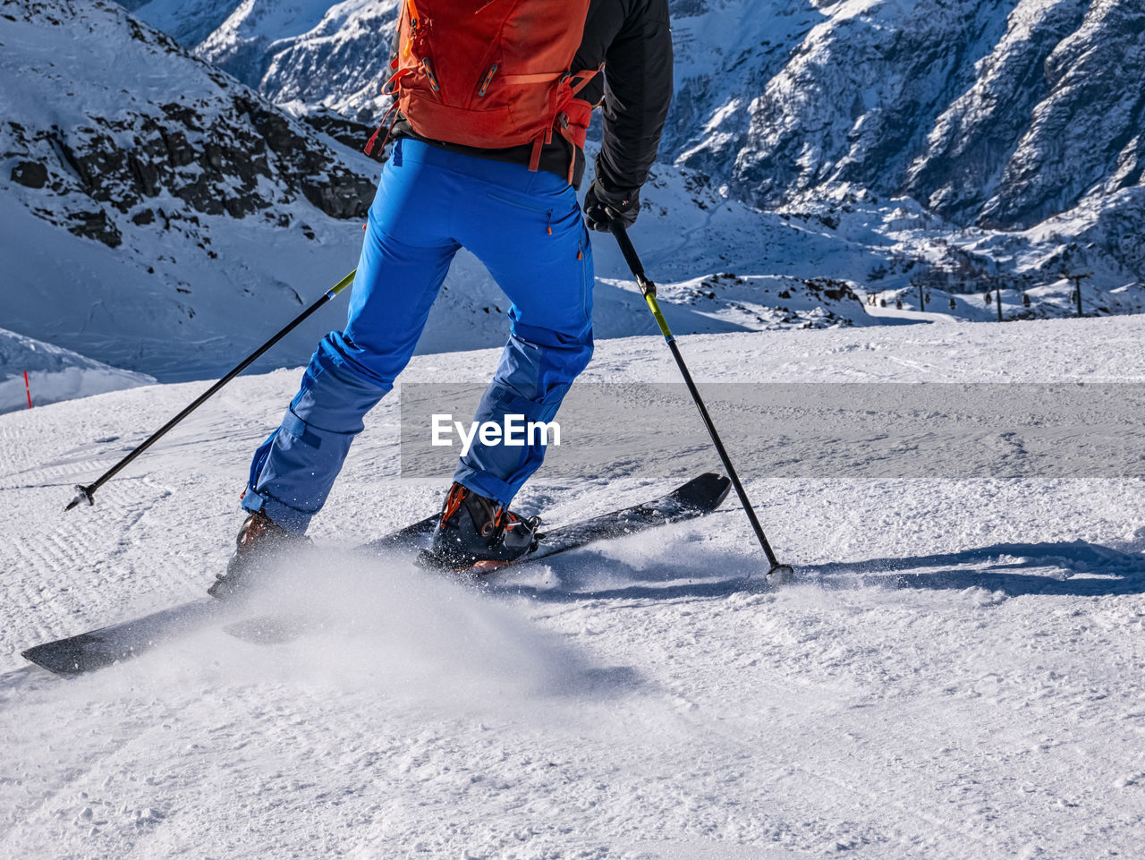 Low section of man skiing on snowcapped mountain