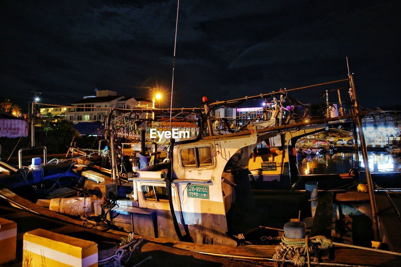 BOATS MOORED AT HARBOR AGAINST SKY