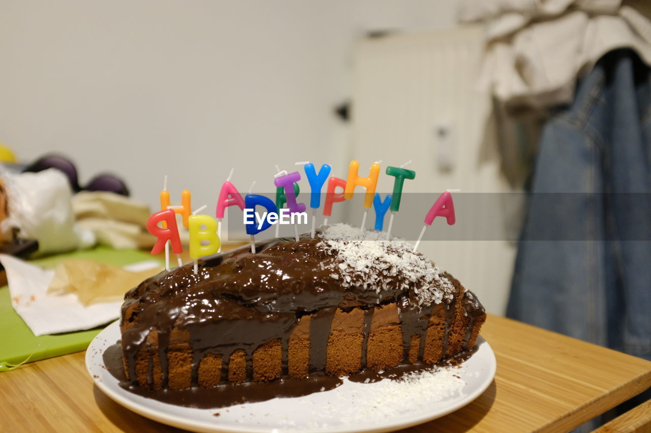 Close-up of birthday cake with text on table