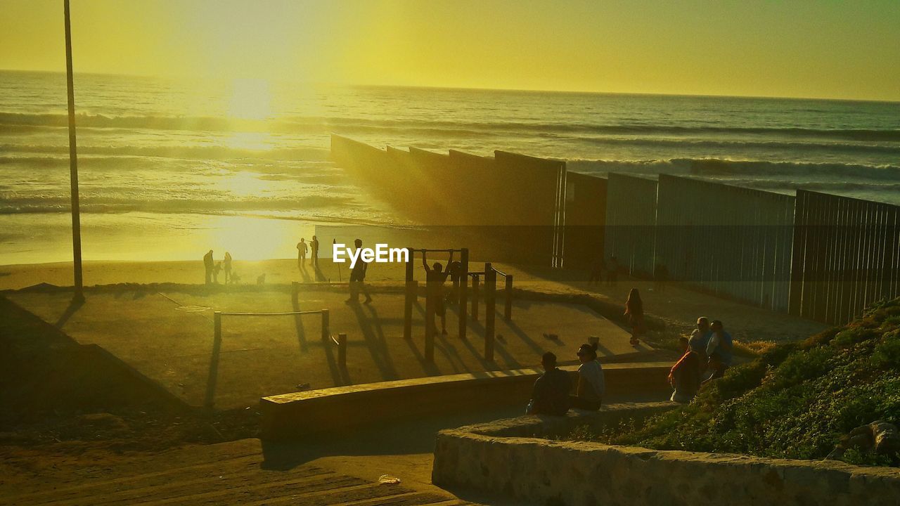 High angle view of people at beach during sunset