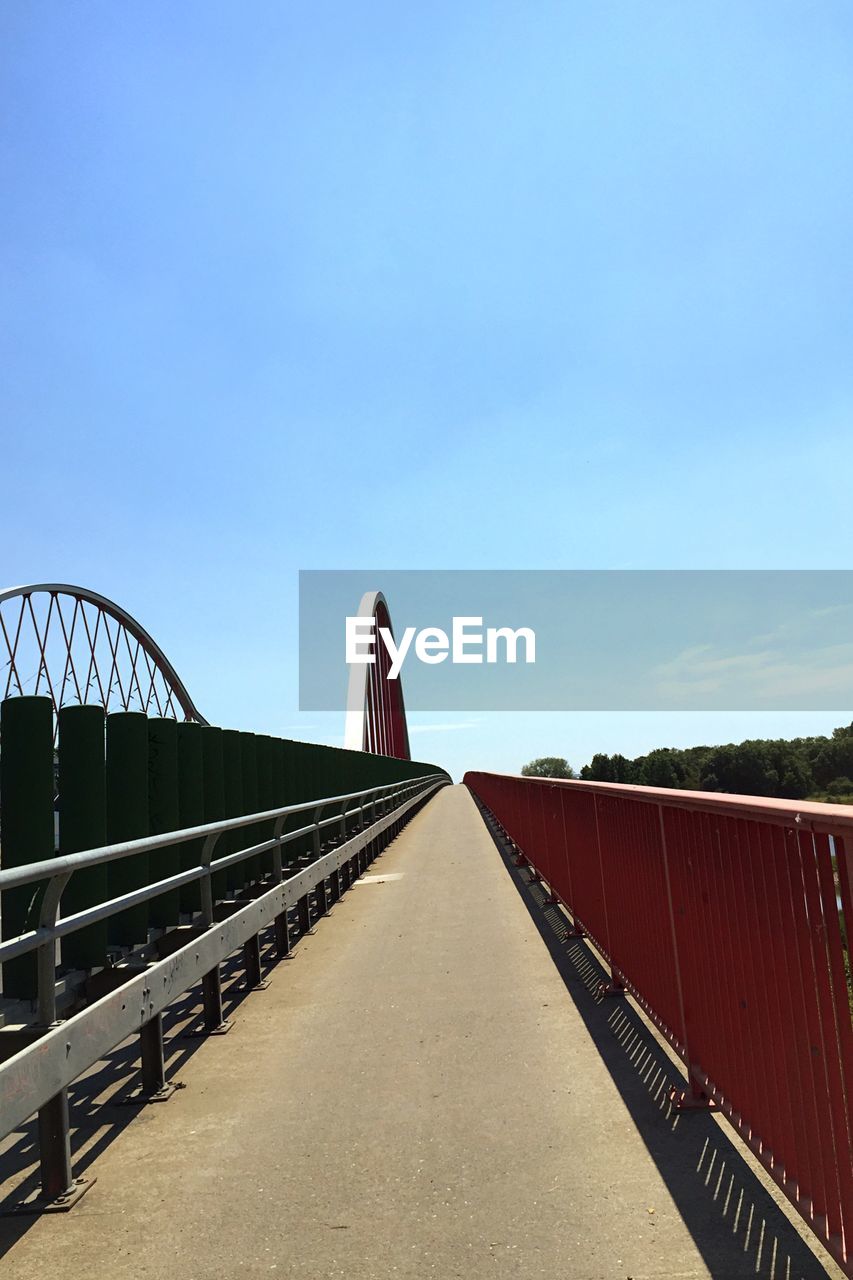 Bridge by railing against sky
