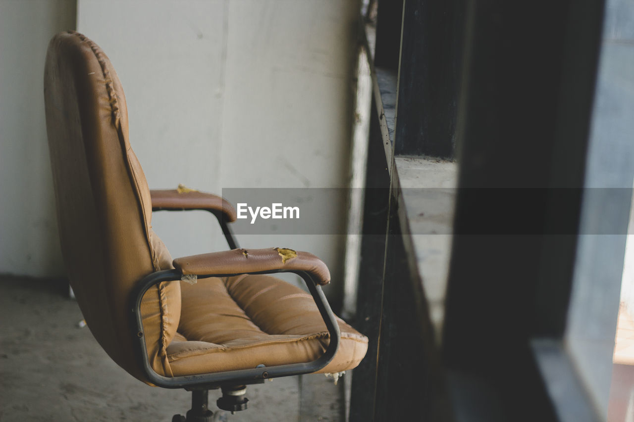 Empty chair against wall at home