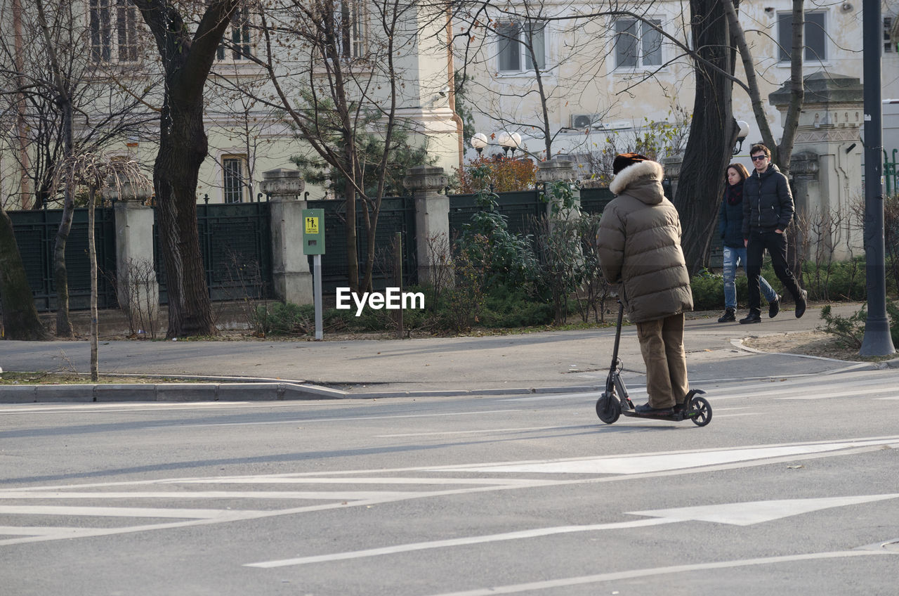 REAR VIEW OF WOMAN ON ROAD