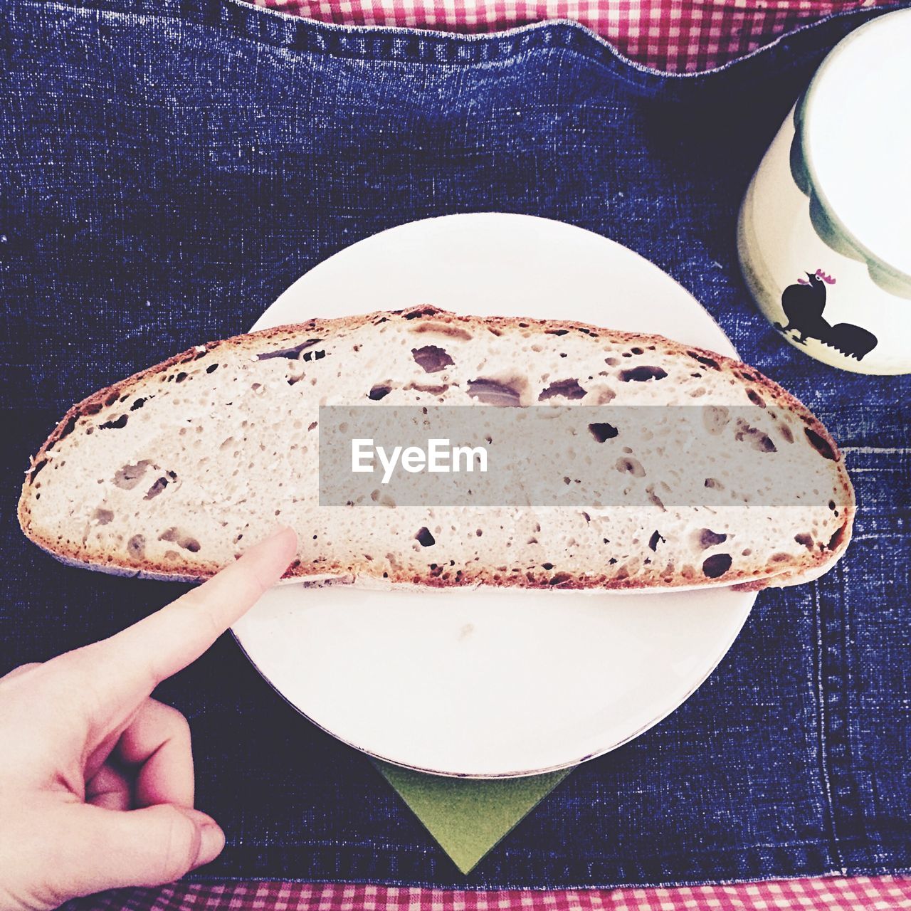 Cropped image of person pointing bread on plate