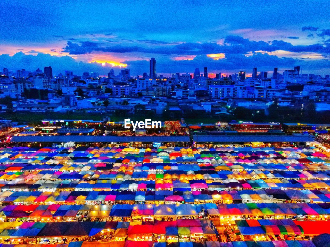 HIGH ANGLE VIEW OF ILLUMINATED BUILDINGS IN CITY