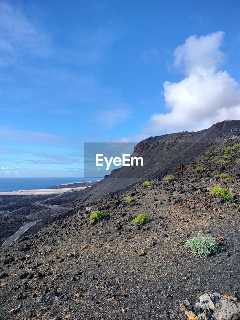 sky, environment, landscape, cloud, mountain, volcano, scenics - nature, nature, land, beauty in nature, volcanic landscape, geology, sea, ridge, non-urban scene, wilderness, no people, rock, travel destinations, lava, day, soil, outdoors, travel, volcanic crater, blue, volcanic rock, coast, tranquility, water, adventure, tranquil scene, physical geography, tourism, plateau