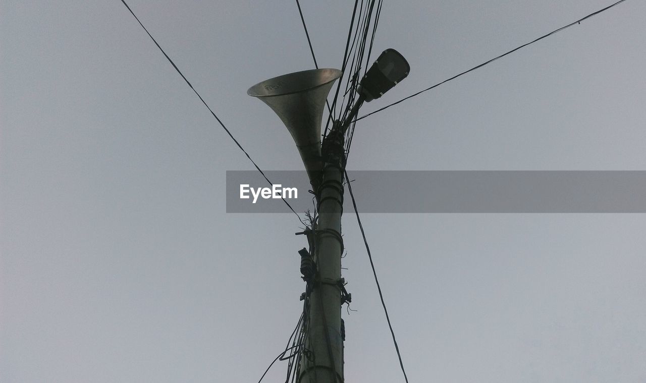 Low angle view of megaphone on street light against clear sky