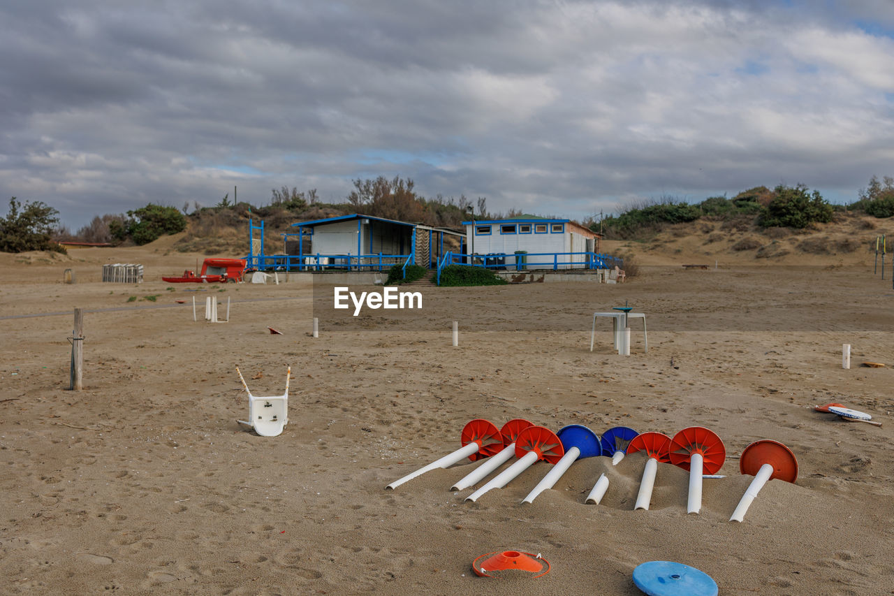 beach, land, sand, cloud, sky, nature, sea, architecture, built structure, no people, hut, coast, environment, day, shore, water, absence, building exterior, vacation, outdoors, trip, holiday, building, landscape, travel destinations, playground, body of water, chair, scenics - nature, multi colored, coastline