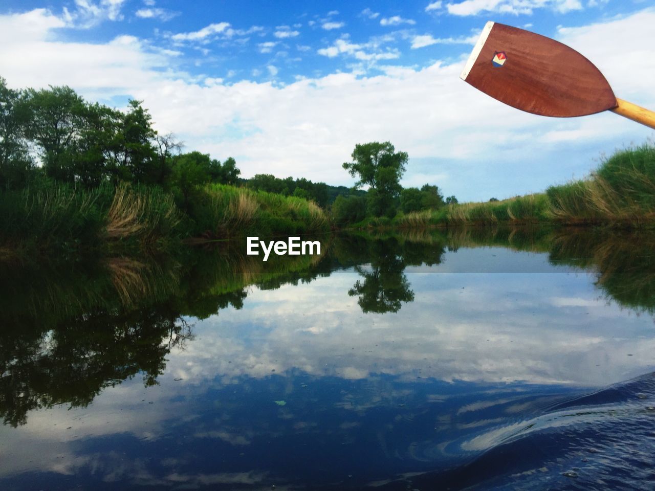 REFLECTION OF TREES IN LAKE AGAINST SKY