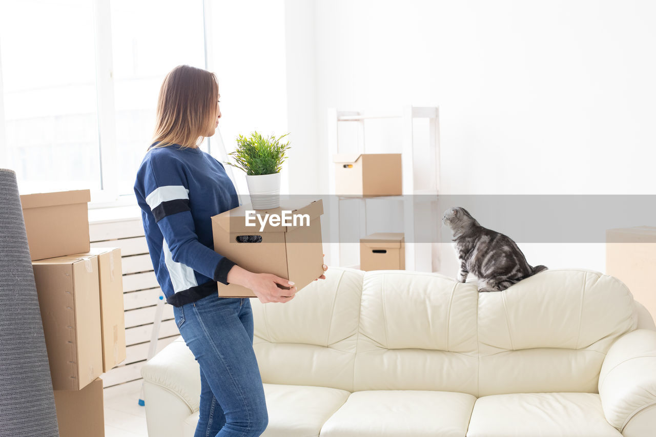 Woman carrying boxes at home