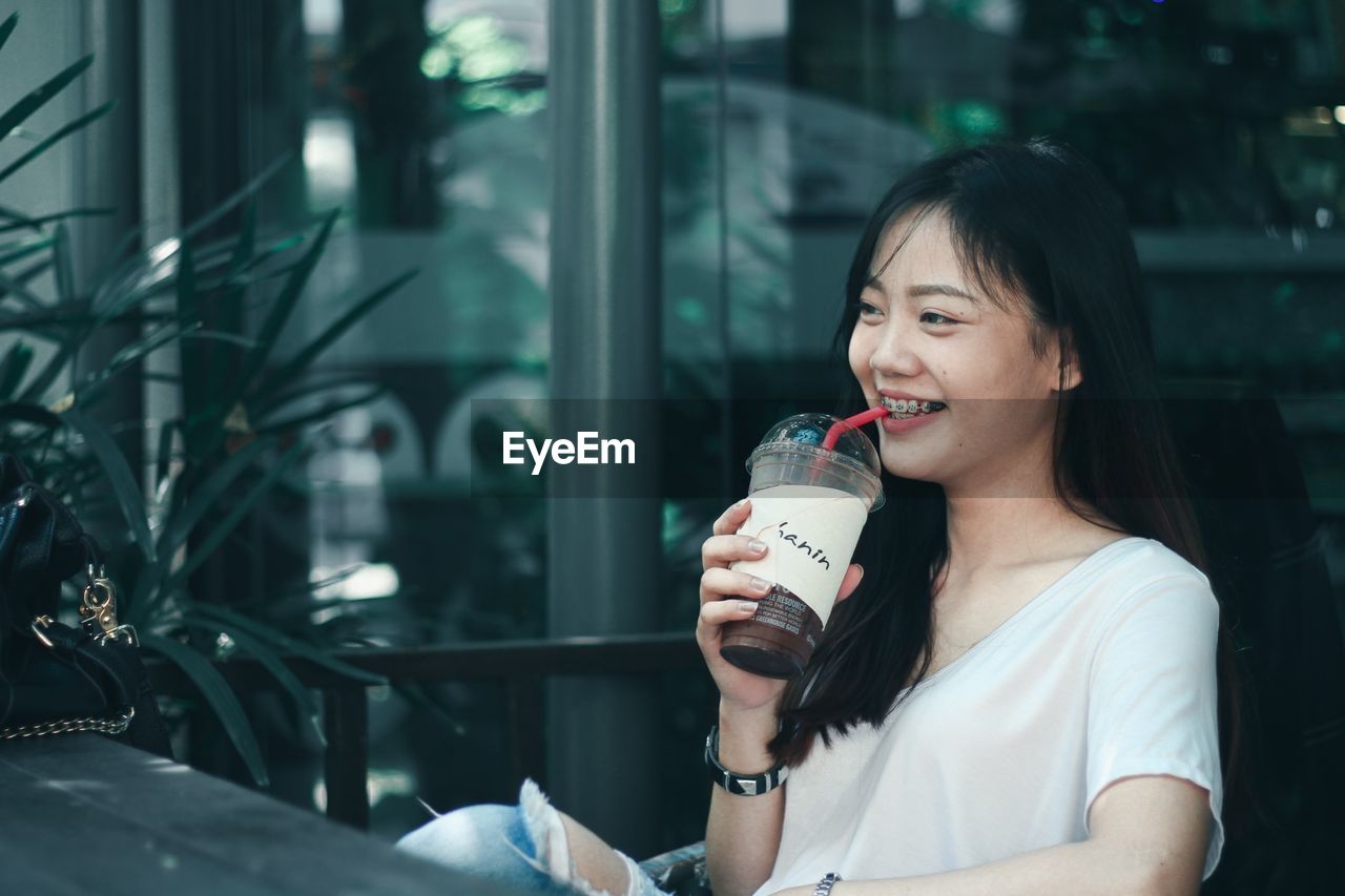 Smiling woman having coffee at cafe