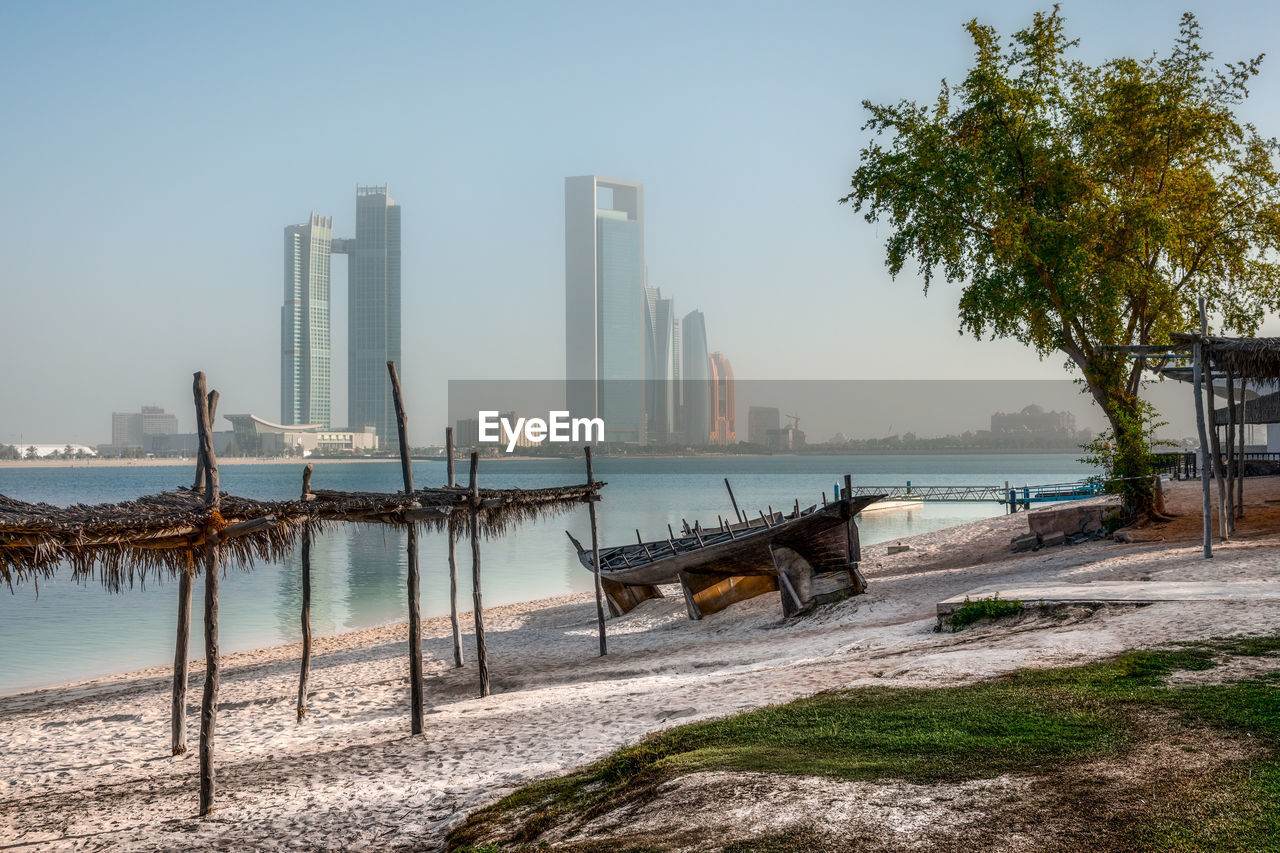 Scenic view of sea by city against clear sky