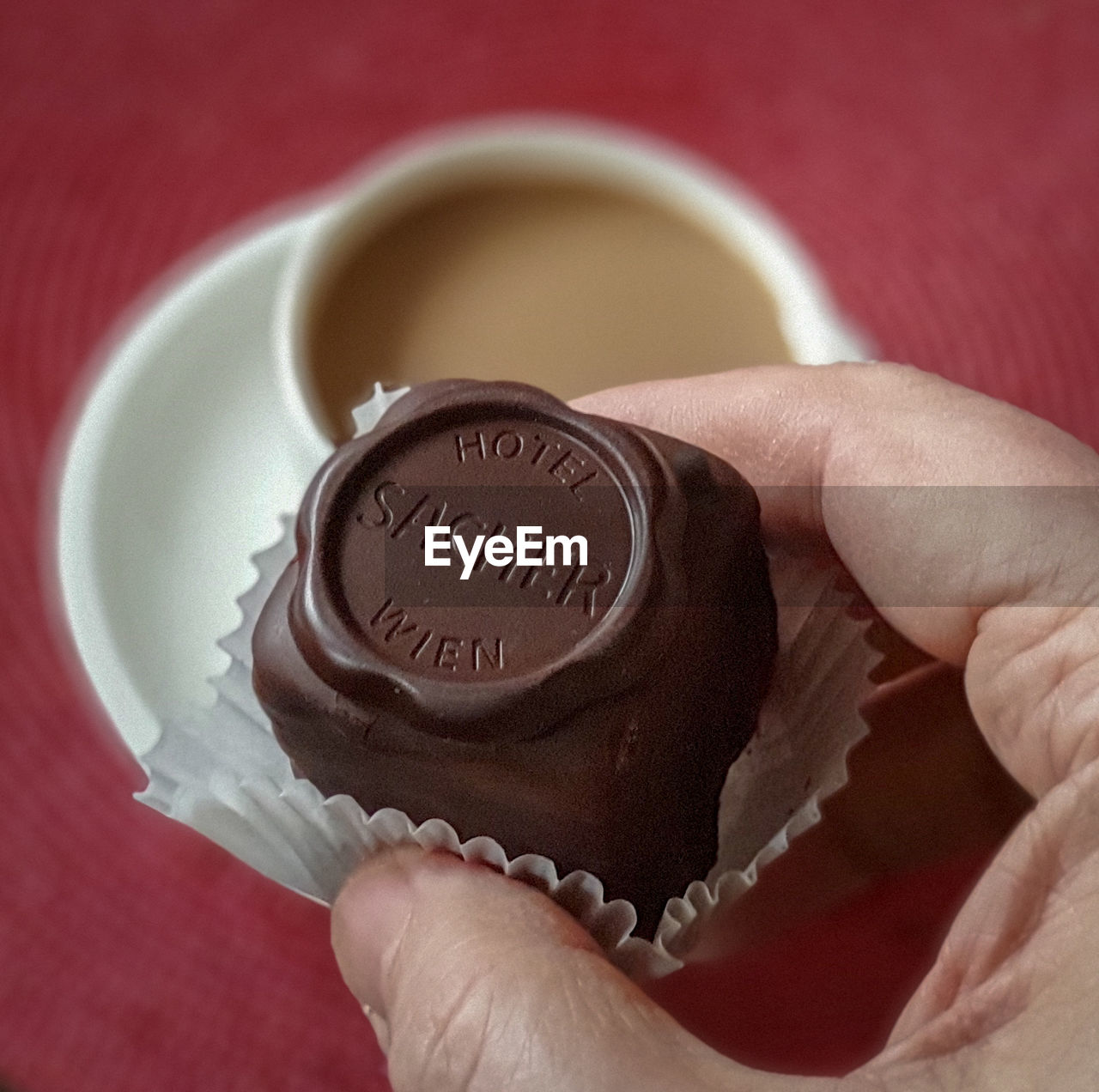 CLOSE-UP OF HUMAN HAND HOLDING DRINK WITH CHOCOLATE