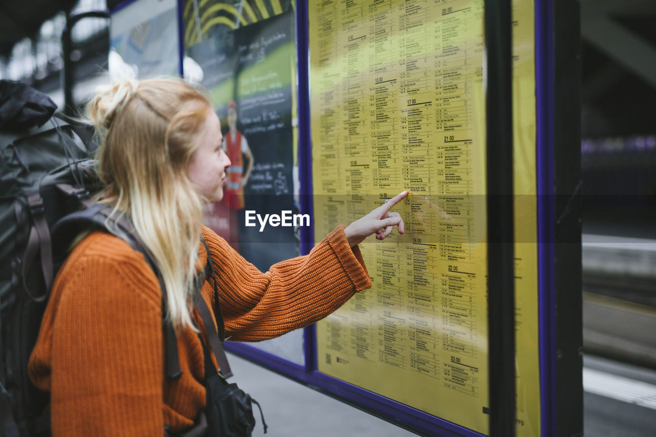 Woman on train station checking timetable