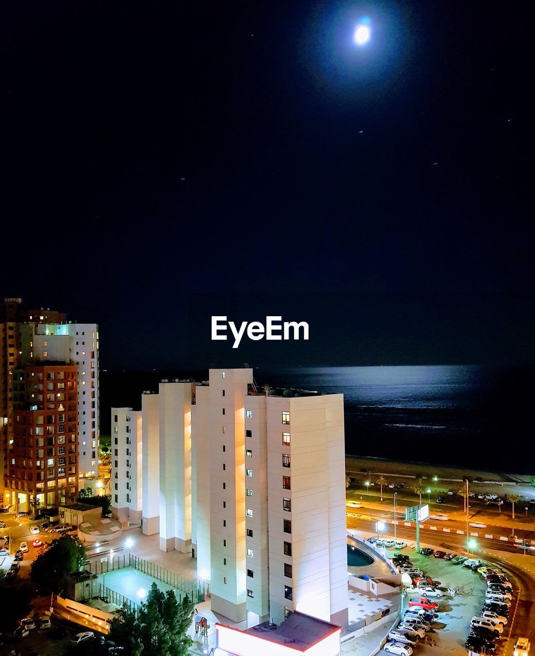 ILLUMINATED BUILDINGS IN TOWN AGAINST SKY