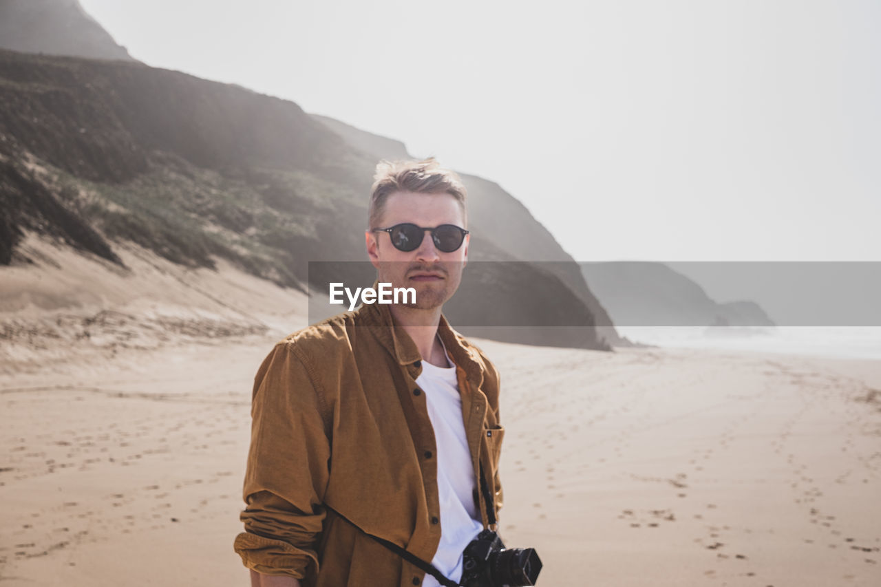 Portrait of young man standing at beach