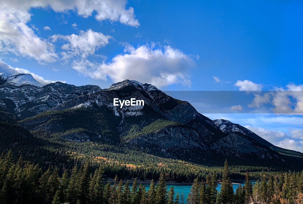 Scenic view of lake by mountains against sky