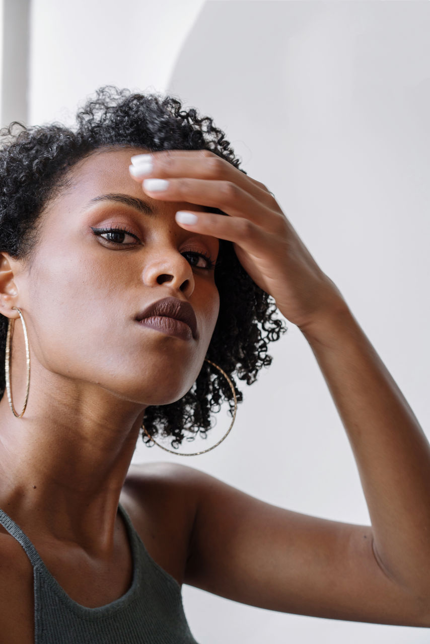 Portrait of a beautiful black woman with curly hair on a white background