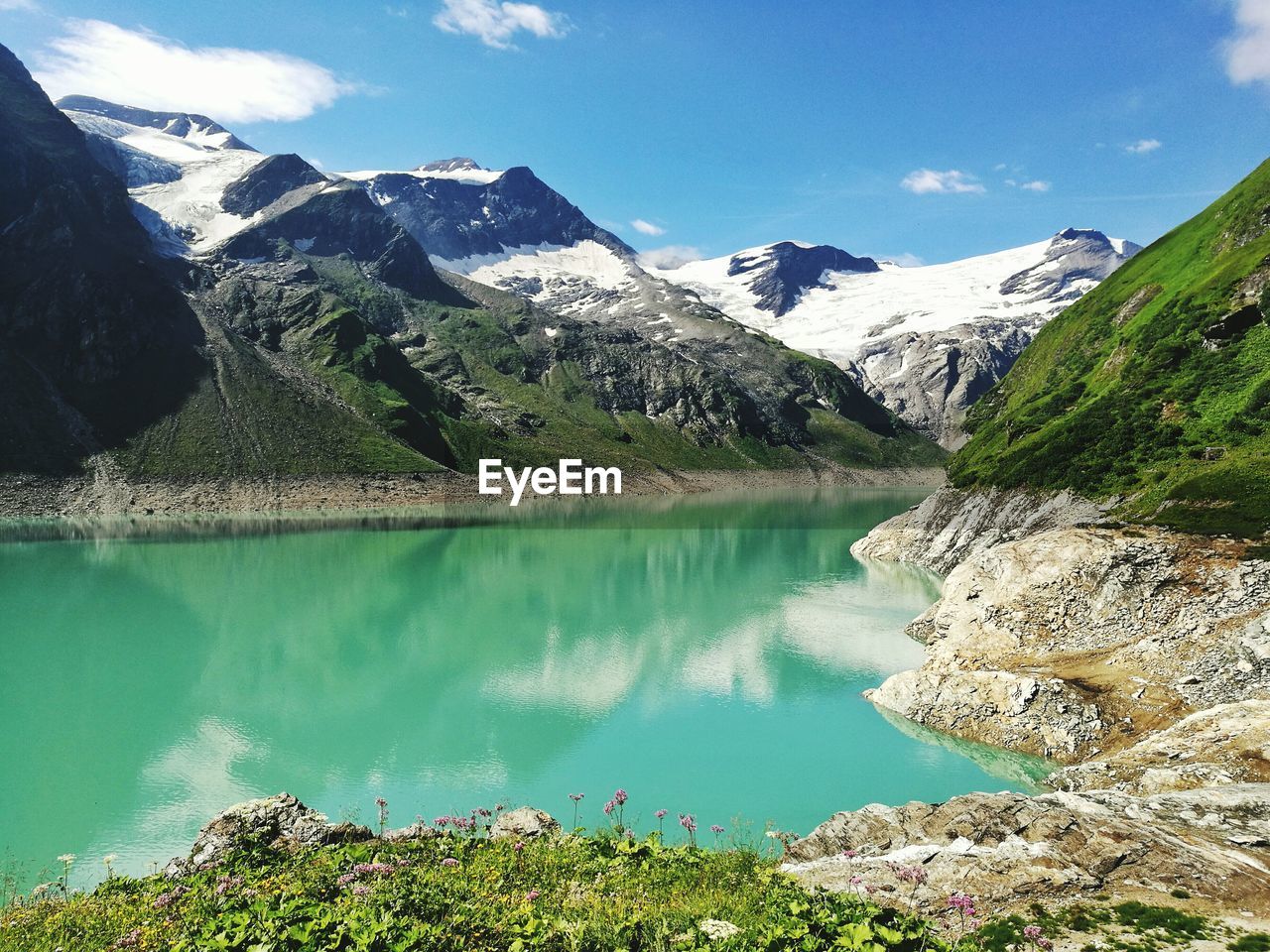 Scenic view of lake by mountains against sky