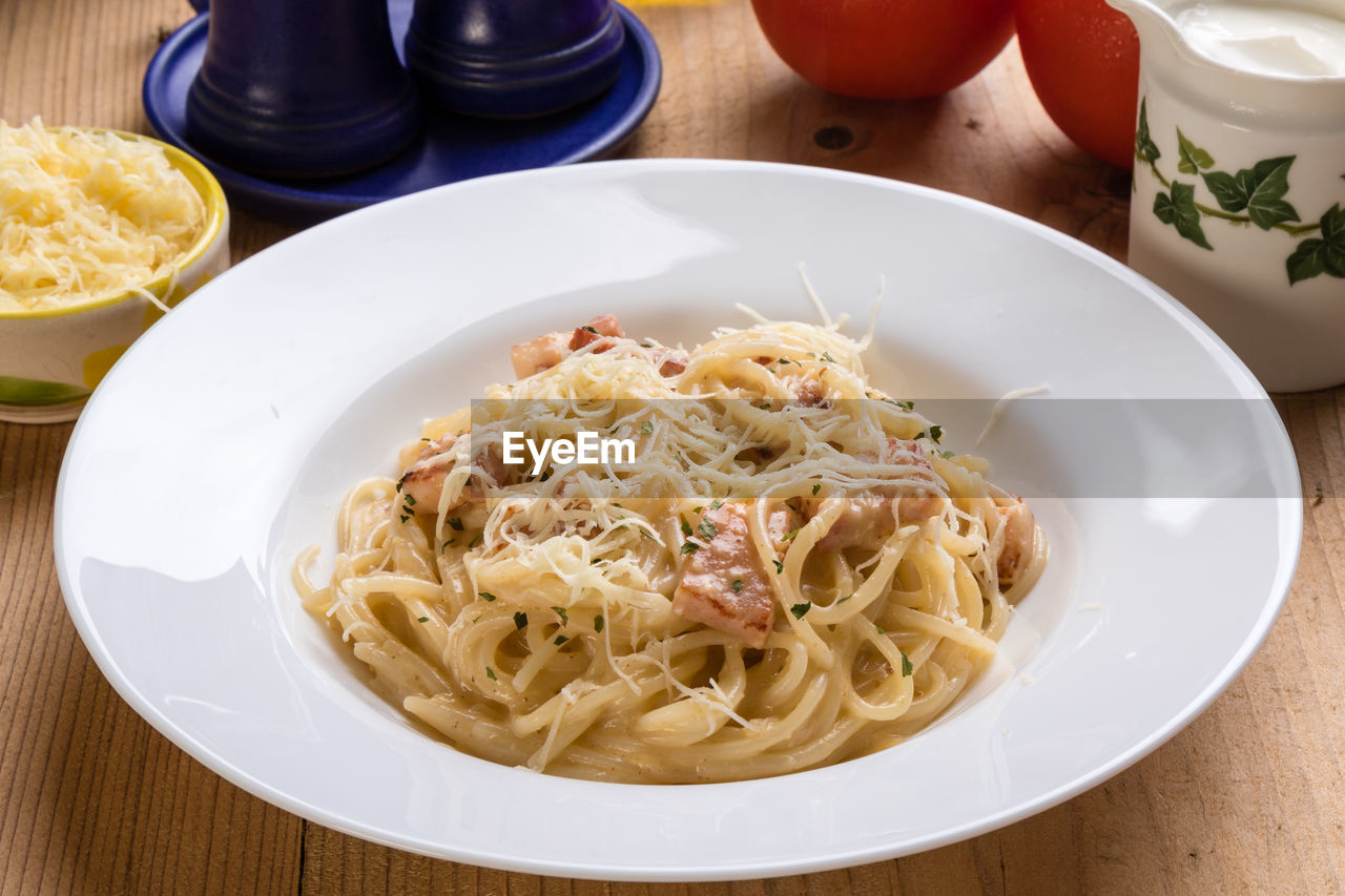 High angle view of spaghetti with carbonara in plate on table