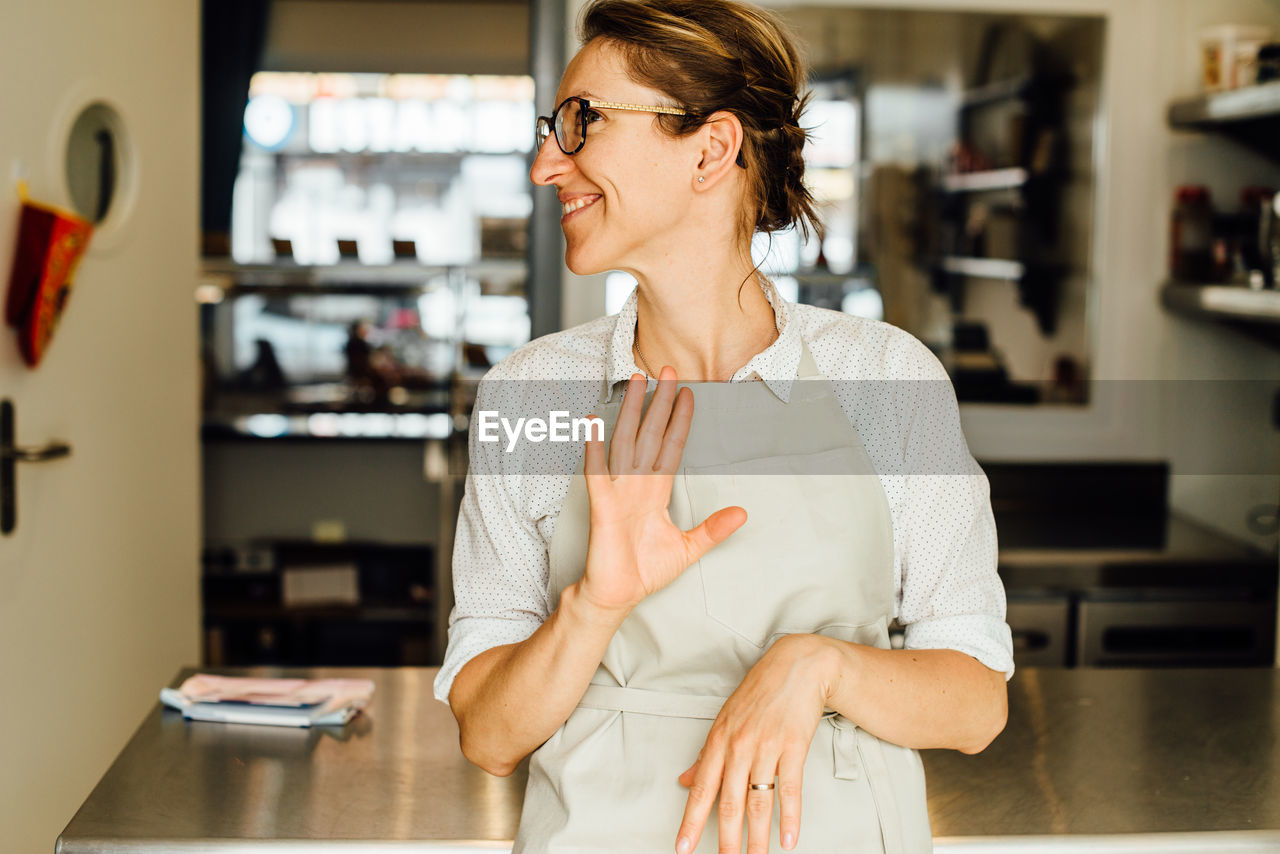 Female chef making gestures while standing at restaurant kitchen