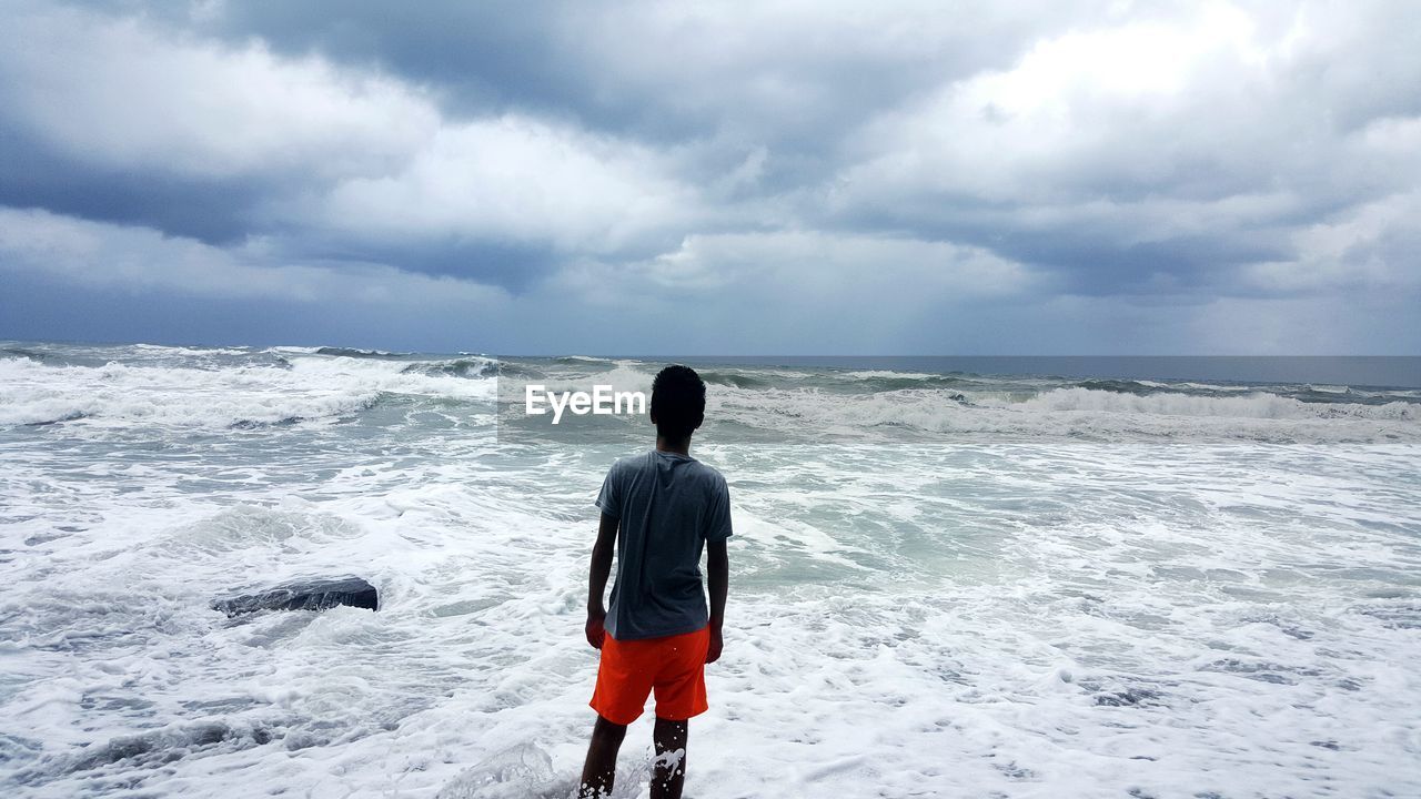 Rear view of man standing on beach