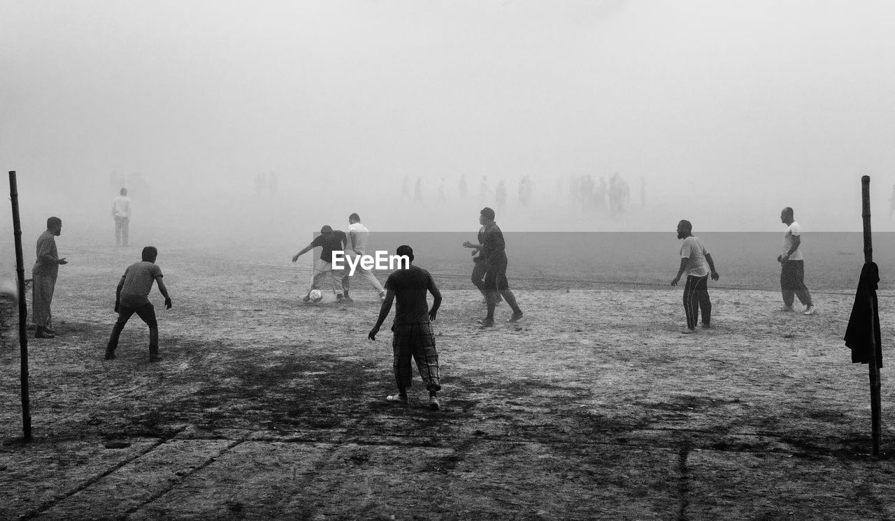 Group of people walking on land against sky