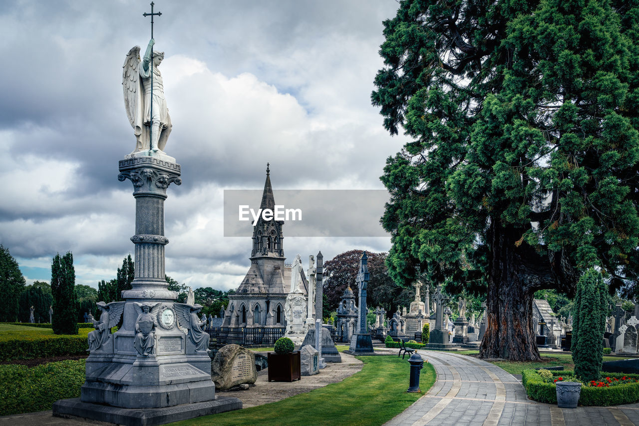 Sculpture of archangel, crypts and graves with celtic crosses in glasnevin cemetery, ireland