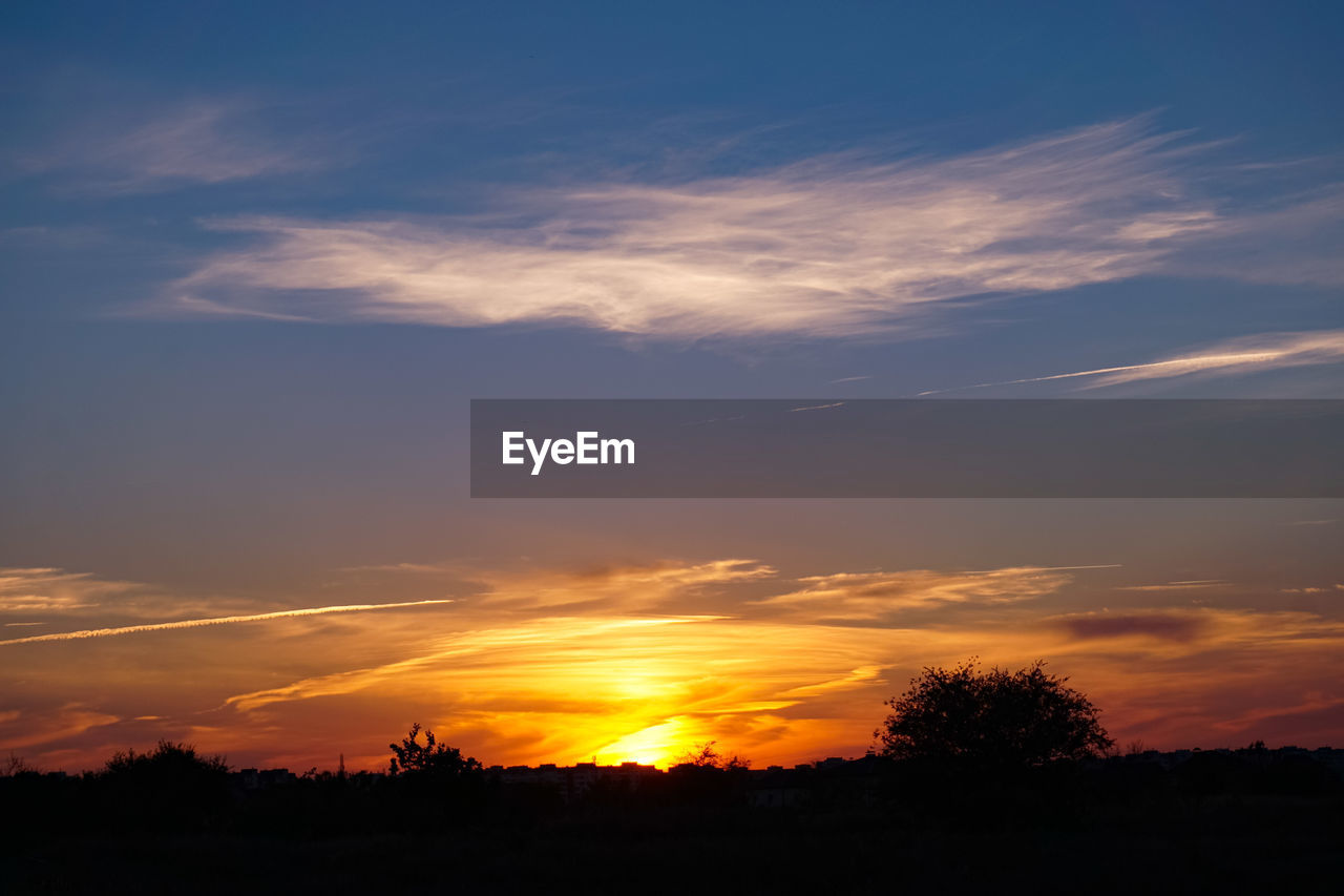 SCENIC VIEW OF SILHOUETTE FIELD AGAINST SKY AT SUNSET