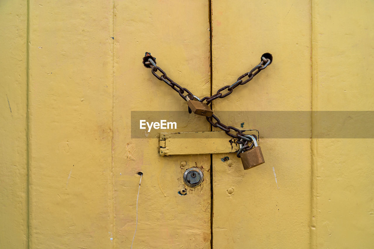 close-up of padlock on yellow wall