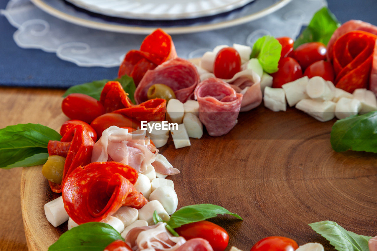 Italian charcuterie wreath with prosciutto, mozzarella, tomato, basil, salami, and olives