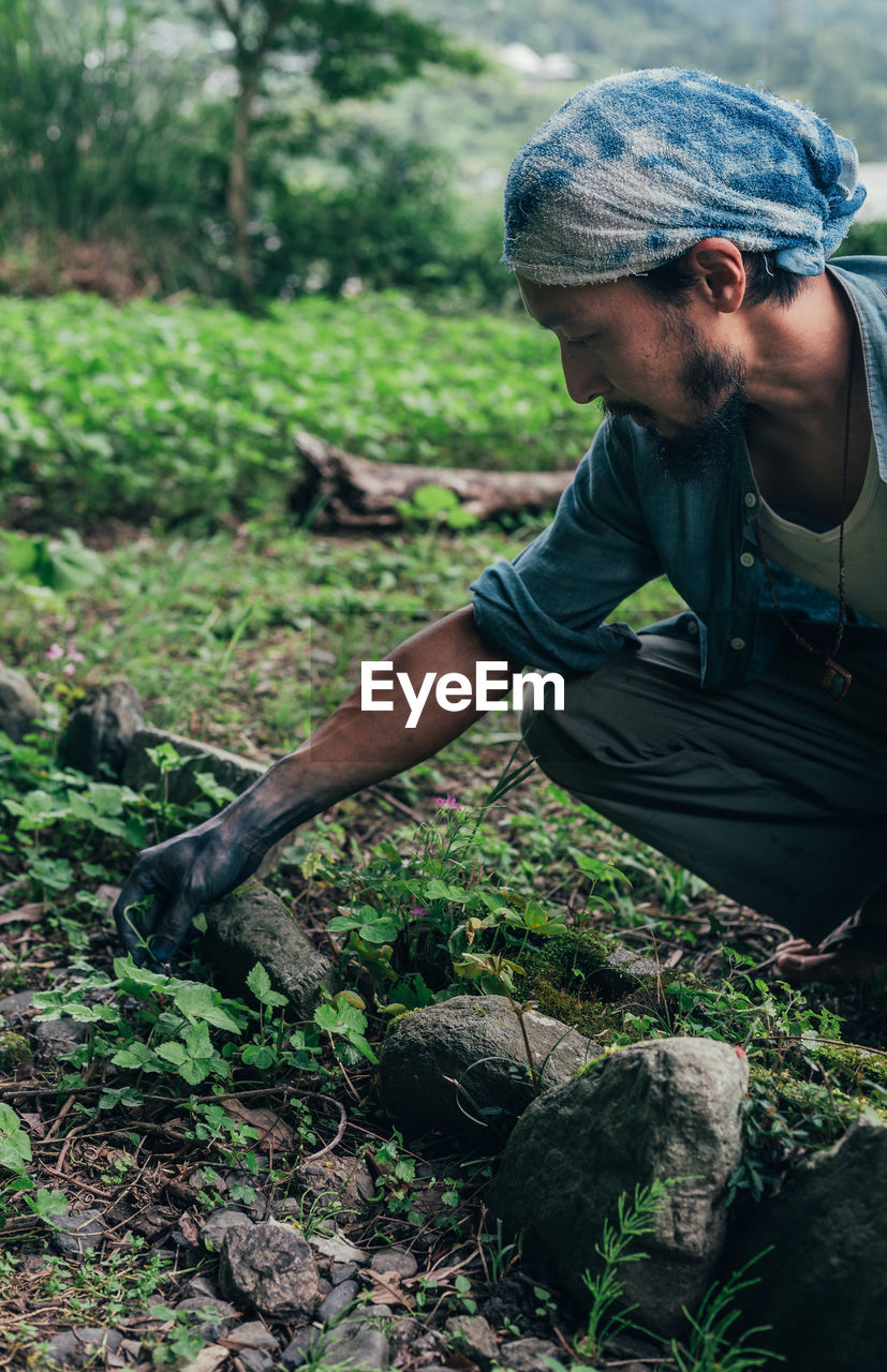 YOUNG MAN LOOKING AWAY IN FIELD